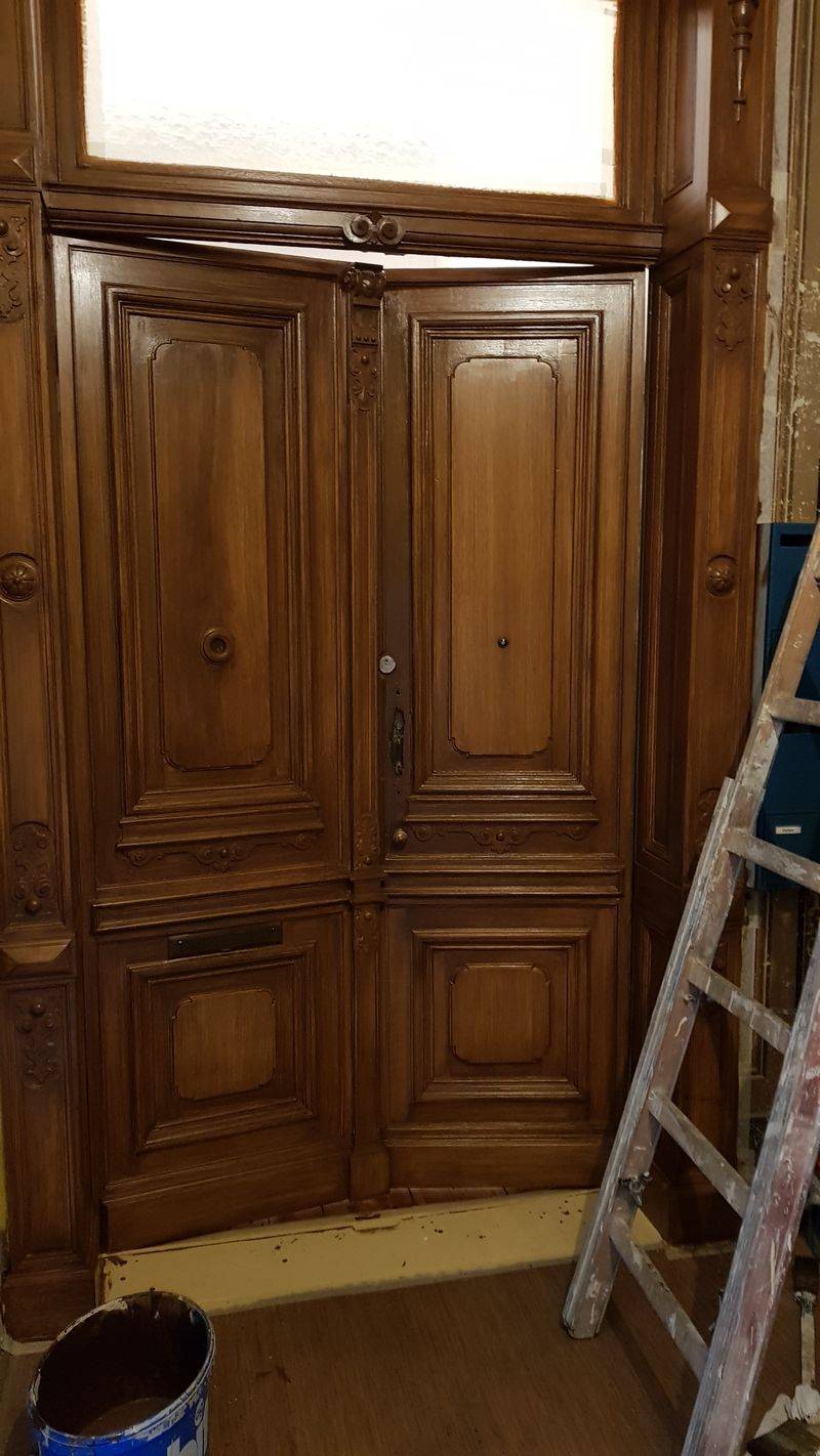 X Holzimitation an einer Wohnungseingangstür in einem Treppenaus aus dem Historismus bzw. aus der Gründerzeit. Das Haus aus dem Bezirk Kreuzberger wurde als hochherrschaftliches Haus für die Militärelite im neu gegründeten Kaiserreich errichtet. Neben dem pompöseren Eingangsbereich und den üppigen Wandschablonen wurde auch die Holzbauteile mit einer Holzmalerei überfasst. An den beiden Türen in der Belletage war die Holzimitation nicht mehr vorhanden. Diese wurde im Zuge der Treppenhaussanierung, wo alle authentischen Malereien von den polymeren Farben entfernt und damit sichtbar gemacht wurden, wiederhergestellt. An den restlichen Türen sind noch alle bauzeitlichen Holzmalereien erkennbar. Die Holzimitation lehnt sich an den historischen Originalen an. Durch die Erfahrungen als Restaurator und Malerfirma stellte diese Arbeit kein großes Problem für das Unternehmen restaurierung & gestaltung dar. Das Haus ist kein Denkmal und seit der Erbauungszeit i. Familienbesitz.